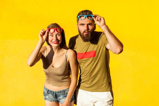 Pareja divertida en ropa de estilo casual y gafas de colores