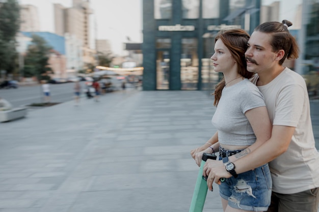 La pareja se divierte conduciendo un scooter eléctrico por la ciudad.