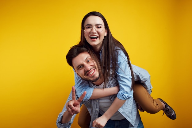 Foto pareja se divierte juntos hombre da caballito a mujer