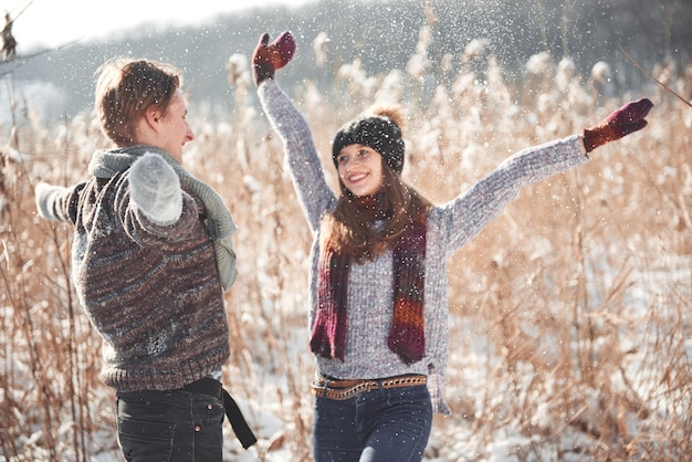 La pareja se divierte y se ríe. Beso. Pareja joven inconformista abrazándose en el parque de invierno. Historia de amor de invierno, una hermosa pareja joven y elegante. Moda de invierno con novio y novia