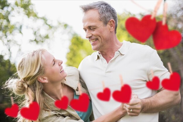 Pareja divirtiéndose con corazones rojos colgantes