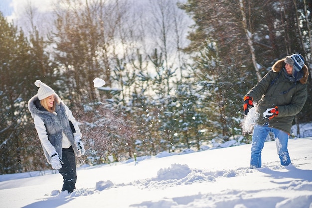 Pareja divirtiéndose en la nieve y el paisaje de invierno. Foto de alta calidad