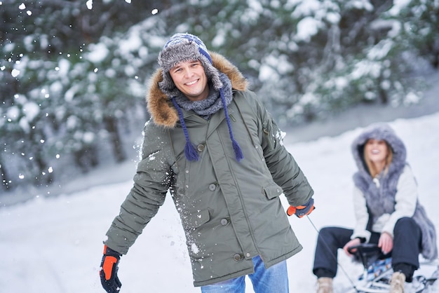 Pareja divirtiéndose con trineo sobre la nieve en la nieve del invierno. Foto de alta calidad