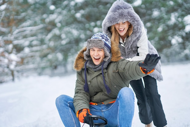 Pareja divirtiéndose con trineo sobre la nieve en la nieve del invierno. Foto de alta calidad