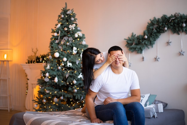 Pareja en el dormitorio con decoración navideña.