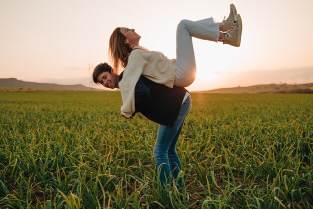 Pareja de dos personas, un chico caucásico y una chica. Los dos juegan felices en un ambiente.