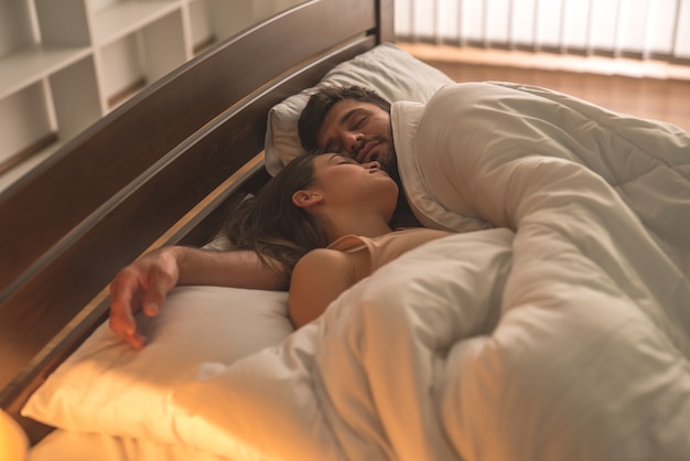 La pareja durmiendo se relaja en la cama.