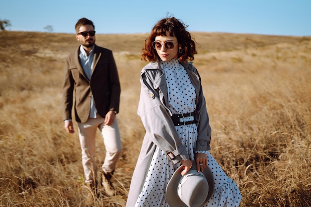 Una pareja elegante y amorosa disfrutando el uno del otro al aire libre Una pareja elegante caminando y abrazándose