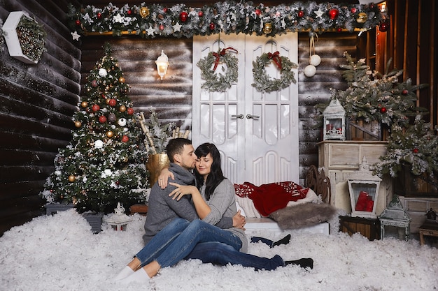 Foto pareja elegante delante de la casa con adornos navideños