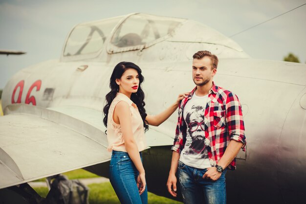 Pareja elegante de pie cerca de la aeronave