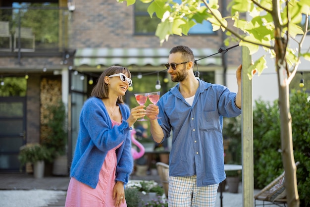 Una pareja elegante toma una copa en el patio trasero