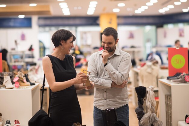 Una pareja elige zapatos en una zapatería.