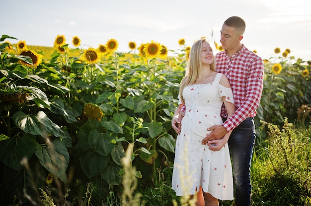 Pareja embarazada en el campo de girasoles. Momentos felices del embarazo