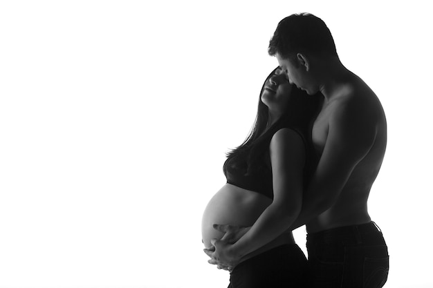 Pareja embarazada feliz junto con fondo blanco.