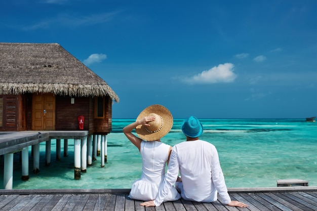 Pareja en un embarcadero de playa en Maldivas