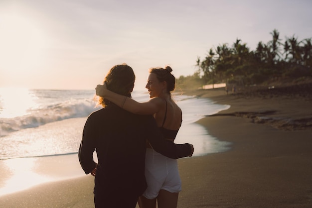 Una pareja enamorada en un abrazo admira la vista del océano desde atrás