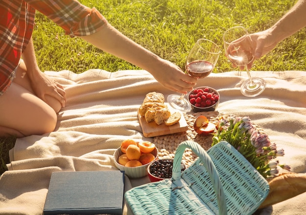 Pareja enamorada bebiendo vino tinto en un picnic