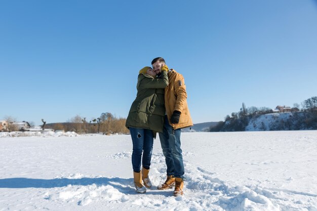 Pareja enamorada besándose en un día soleado de invierno