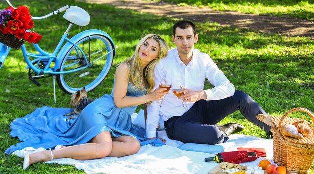 Pareja enamorada celebrando el compromiso familia feliz en el parque comida y bebida hombre y mujer con perro