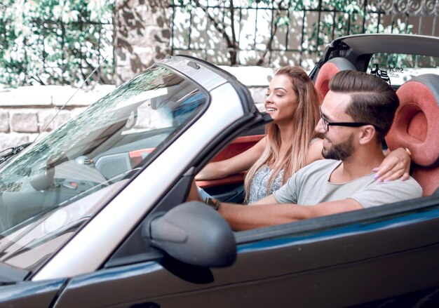 Pareja enamorada en un coche descapotable