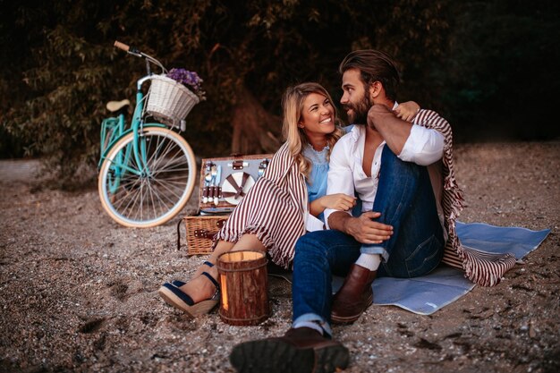 Pareja enamorada cubierta de manta disfrutando juntos de un picnic