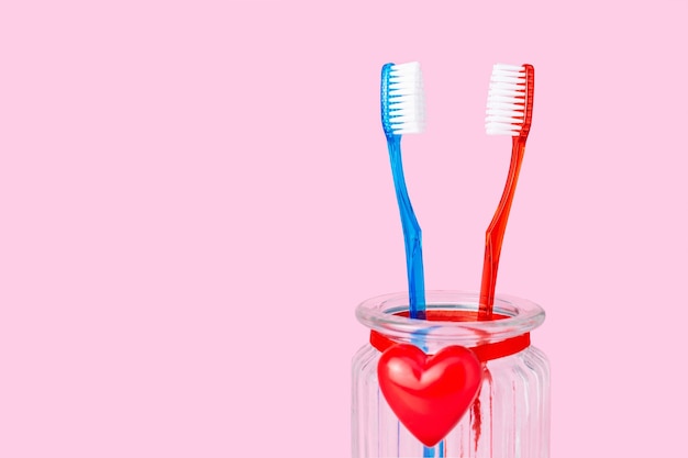 Foto una pareja enamorada, dos cepillos de dientes con un corazón rojo, amor, relación, hombre y mujer, marido y mujer, día de san valentín