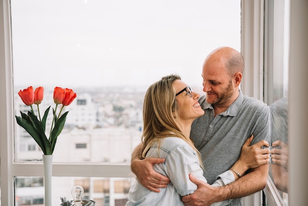 Foto pareja enamorada enfrente de ventana