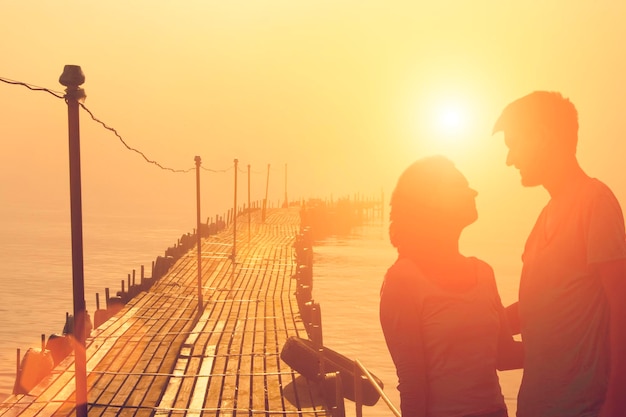 Pareja enamorada en el fondo del mar el cielo y el muelle