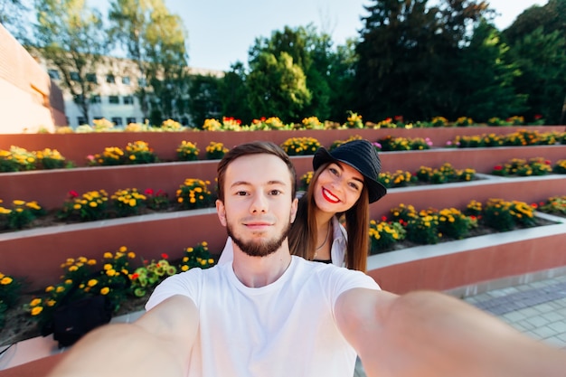 La pareja enamorada hace un sephie en el fondo de un macizo de flores multinivel