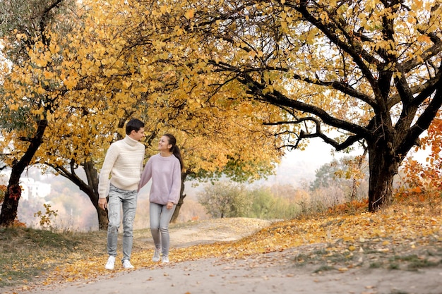 Pareja enamorada en las hojas de otoño