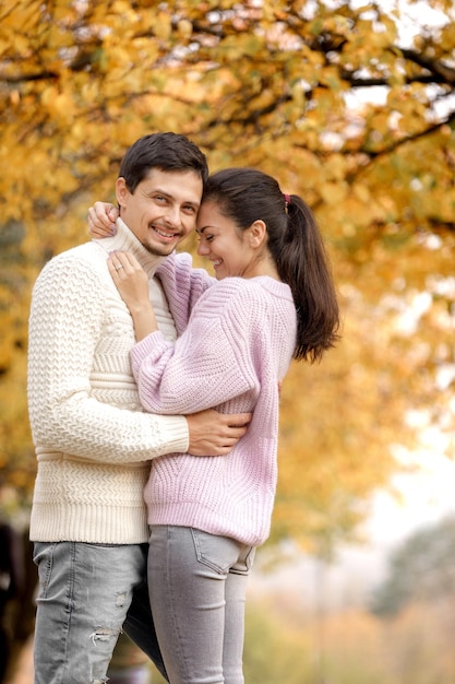 Pareja enamorada en las hojas de otoño