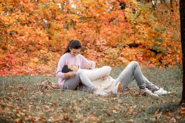 Pareja enamorada en las hojas de otoño