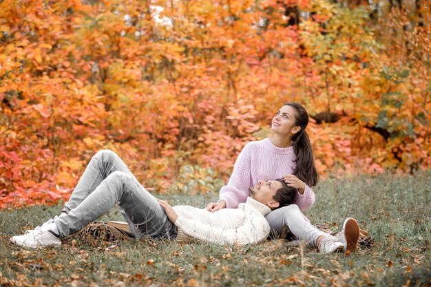 Pareja enamorada en las hojas de otoño