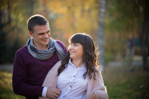 Una pareja enamorada se mira a los ojos en el parque de otoño