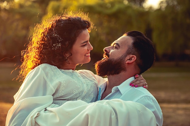 Pareja enamorada mirándose en un bosque al atardecer