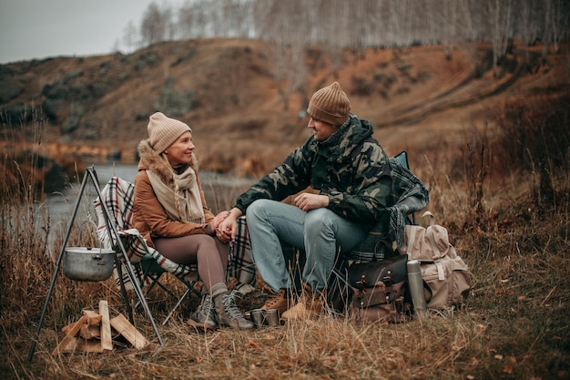 Pareja enamorada en otoño en un camping cerca del río