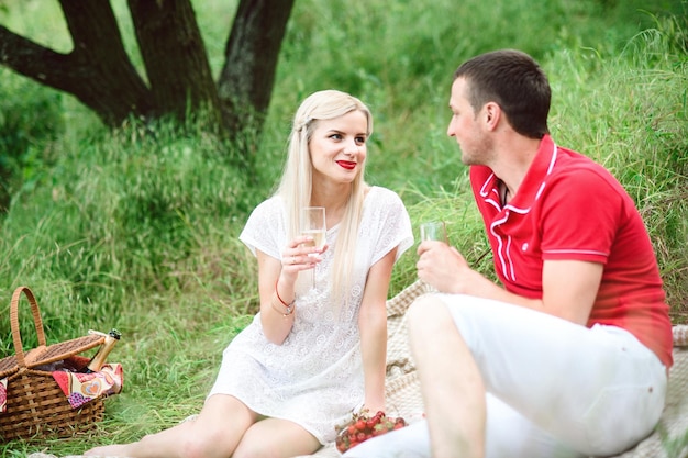 Pareja enamorada en un picnic en un parque con hierba verde