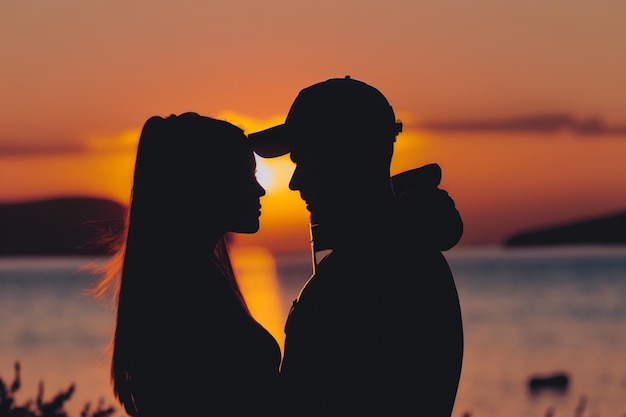 Una pareja enamorada de la puesta de sol detrás de ellos.