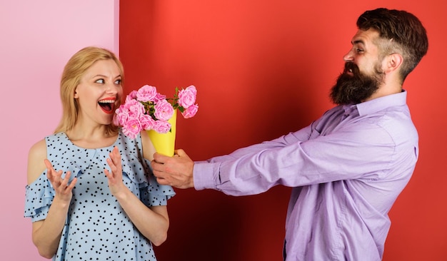 Pareja enamorada de ramo de flores guapo hombre barbudo da rosas a mujer relación amorosa