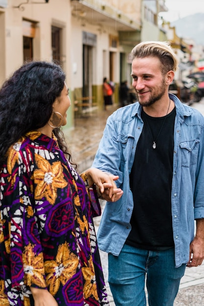 Pareja enamorada sonriendo y caminando por la calle.