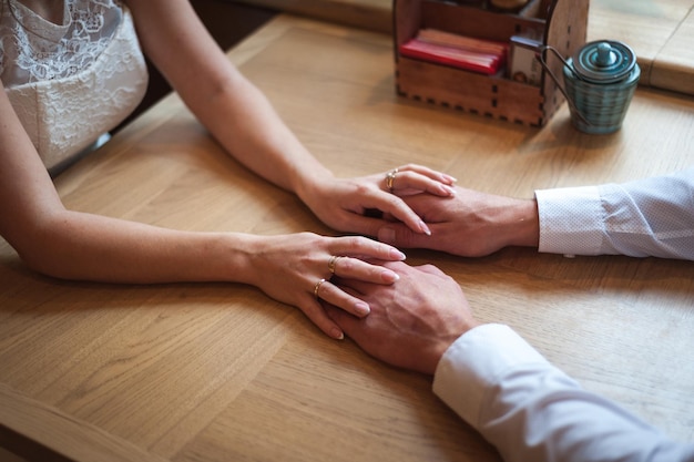 Foto pareja enamorada tomados de la mano en un café centrarse en las manos