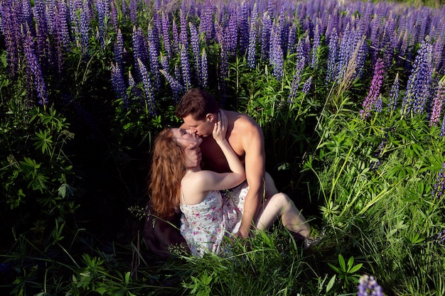 Una pareja de enamorados se abrazan en un campo de flores brillantes y hermosas.