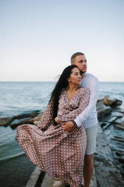 Pareja de enamorados abrazándose en la playa