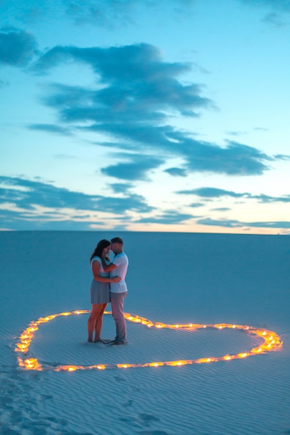 Foto pareja de enamorados abrazos románticos en el desierto de arena