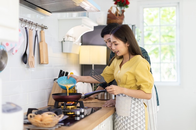 Foto pareja de enamorados ayudando a cocinar en un ambiente romántico