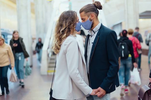 Pareja de enamorados besándose de pie en una estación de metro. estilo de vida urbano.