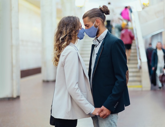 Pareja de enamorados besándose de pie en una estación de metro. estilo de vida urbano.