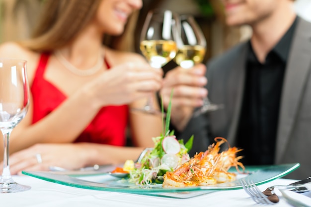 Pareja de enamorados brindando con champán en el restaurante