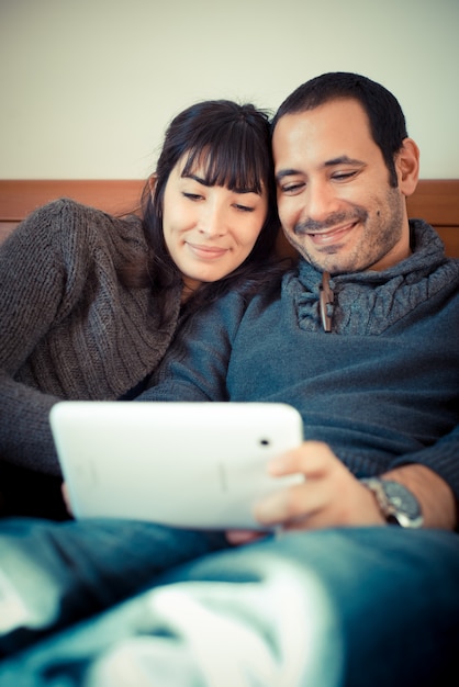 pareja de enamorados en la cama usando tableta