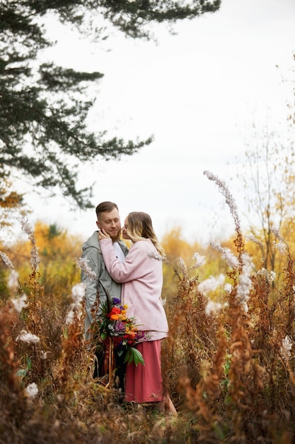 Pareja de enamorados camina por el bosque de otoño